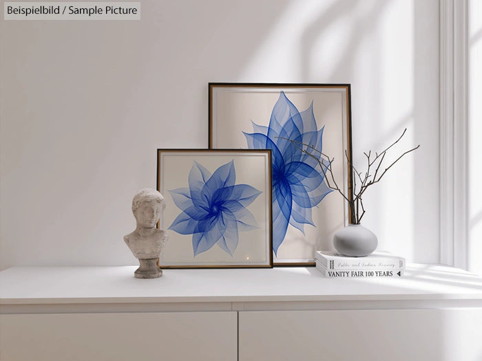 Modern minimalist decor with blue floral art, bust sculpture, and neutral vase on a white sideboard in sunlight.