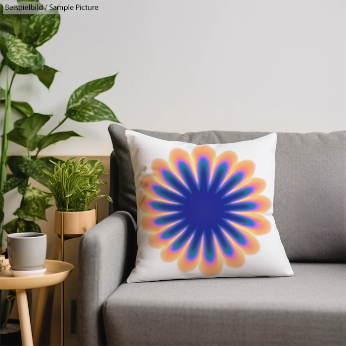 Cushion with colorful abstract flower design on a gray sofa near a plant and coffee table.