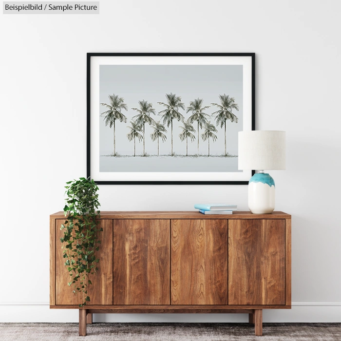 Minimalist room with wooden sideboard, potted plant, and framed palm tree artwork above.