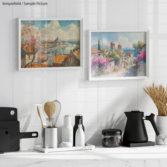 Modern kitchen with framed landscape paintings and kitchen utensils on a white tiled wall.