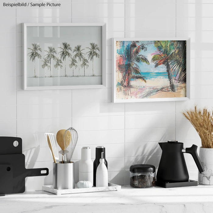 Kitchen scene with framed palm tree art, utensils in a holder, black kettle, and dried grasses on a white counter.