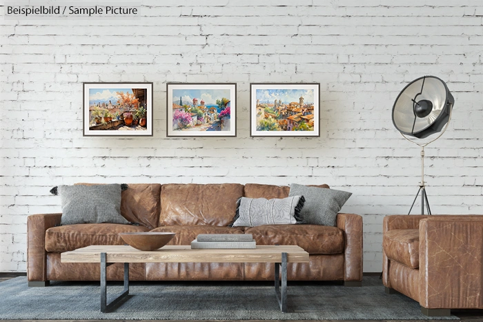Cozy living room with brown leather sofa, industrial floor lamp, and three colorful framed artworks on brick wall.