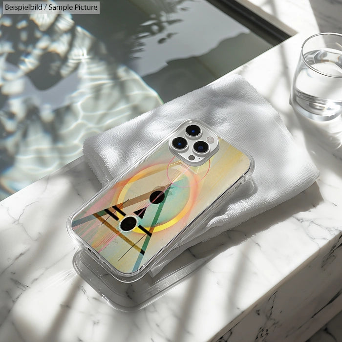 Smartphone with abstract geometric design on case, placed on a marble surface with sunlight reflections.