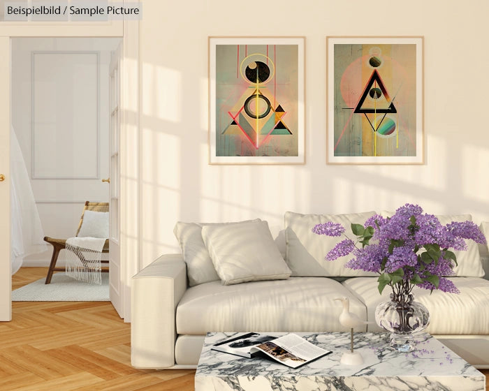 Modern living room with a beige sofa, abstract art on walls, marble coffee table, and vase of purple flowers.